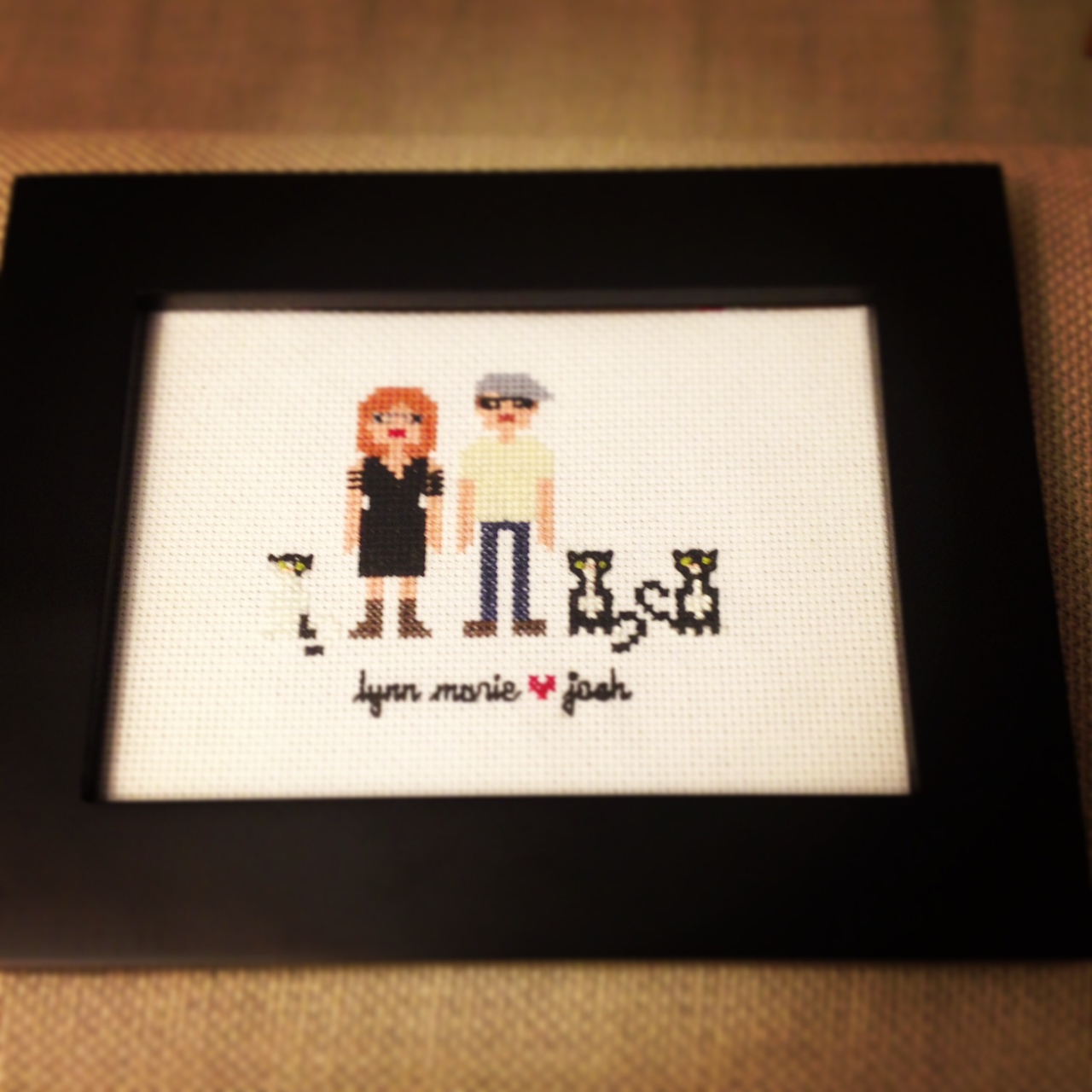 Lynn Marie and Josh as pixel people, cross-stitch