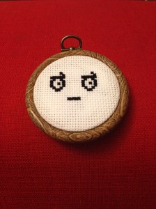 Cross-stitched version of the look of disapproval emoticon.